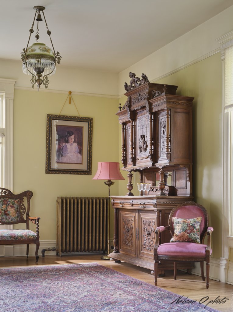 Parlor sitting area with an ornately carved antique cabinet